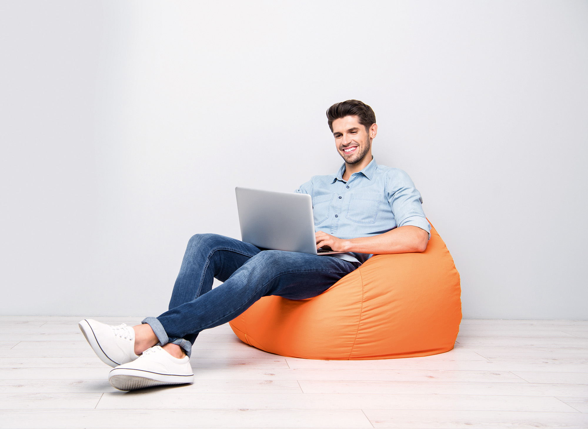 Man with Laptop Full length. Mans sitting back Pouf.